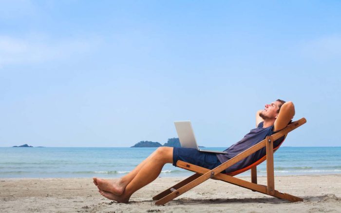 freelancer, happy successful businessman with laptop on the beach, blue sky
